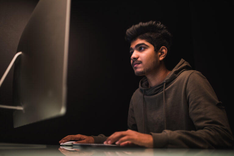 indian man hacker using computers stealing data desk