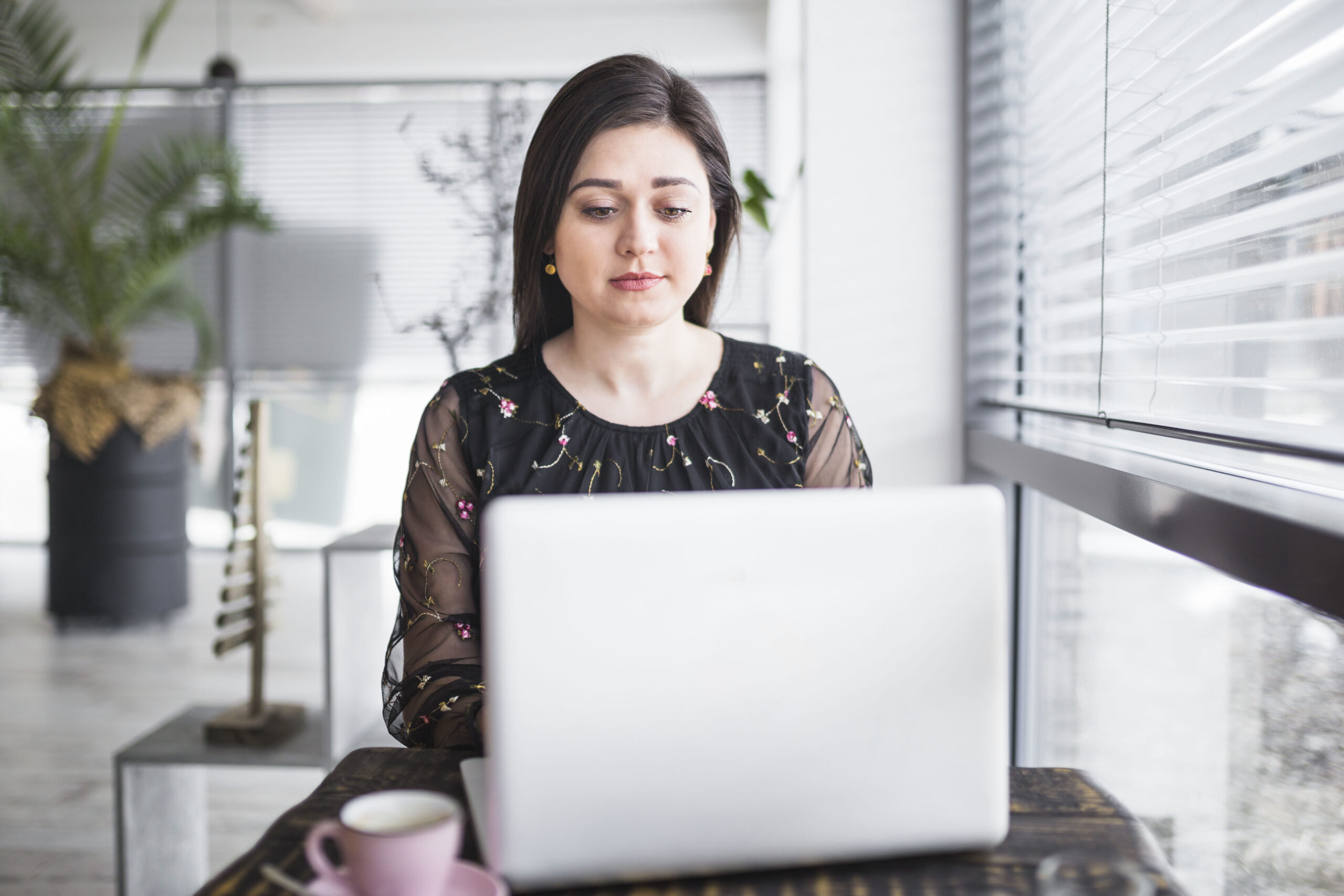 woman using laptop coffee shop 1 scaled